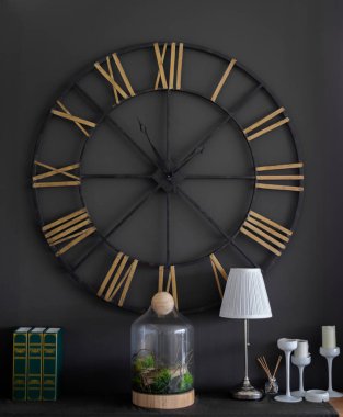 Büyük Vintage çelik saat Romen rakamları Black Wall yeşil Vintage alay kadar kitap, Modern cam şişe, beyaz lamba, beyaz mum Şamdan ile bitki ve Aroma tütsü sopa küçük cam şişe ile üzerinde.