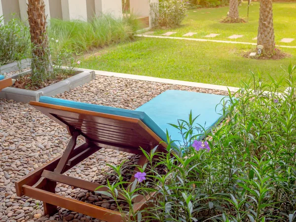 Çakıl ve Hindistan cevizi hurma ağacı bahçede yeşil çim zemin ahşap rahatlatıcı şezlong