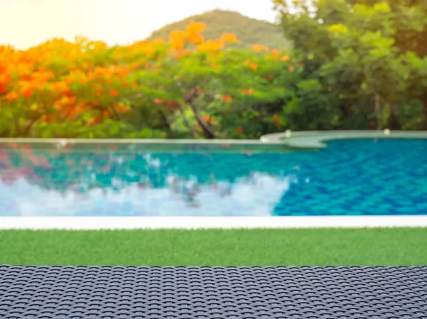 Yüzme Havuzu yakın çekim ile orman çim üzerinde şezlong doku örgü ve bulanık doğa arka plan çiçek.