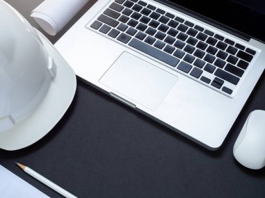 düz beyaz sert güvenlik kask ile dizüstü bilgisayar, bilgisayar fare kontrol, kağıt ve kalem mühendislik alt alanı olan siyah arka plan en iyi görünüm için lay.