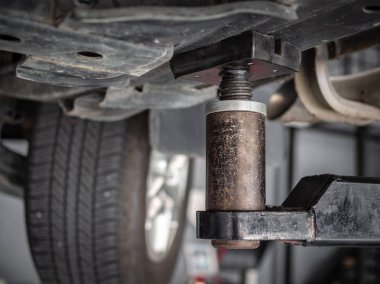 Yakın çekim araba tamir Asansör Makine araba görünümü altında otomobil servis garajında.