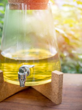 Yedek soğutucu şişe yeşil doğa arka plan üzerinde ahşap masa üzerinde sarı organik vücut bakımı.