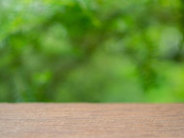Boş ahşap masa üstü olarak yeşil ağaç bahçe arka plan bulanıklık.