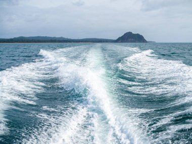 Su akışı hızlı motorlu tekne yağmurlu günde ada manzaralı denizde hareket. Tayland seyahat hedef.