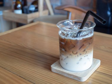 Buzlu kahve kabı Kupası ahşap masa kafede siyah tüp ile. kahve eşsiz konsepti ile kopya alanı.