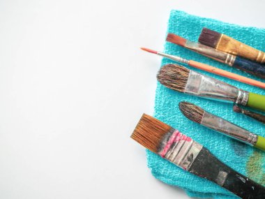 Sanatçı boya fırçaları izole kopya alanı beyaz zemin üzerine mavi küçük havlu üzerinde satır.