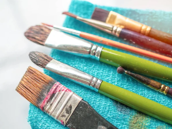 Sanatçı Boya Fırçaları Beyaz Zemin Üzerine Mavi Küçük Havlu Üzerinde — Stok fotoğraf