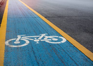 Bisiklet şeritli. Kopya alanı ile eski yolda mavi ve sarı zemin üzerine beyaz bisiklet simgesi.