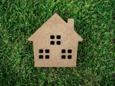 Yeşil çim zemin üzerinde yatıyordu düz ahşap ev. Ev ekoloji kavramı