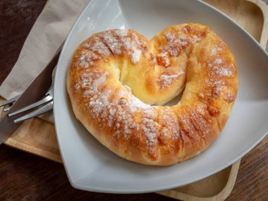 Tatlı üstüne şeker beyaz plaka üzerinde bıçak, ahşap masa arka plan üstten görünüm üzerinde çatal o ahşap tepsi ile ekmek.