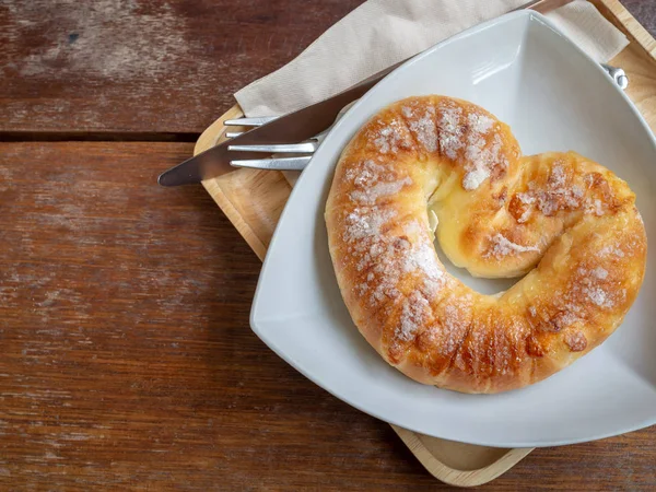 Düz bıçak, çatal o ahşap tepsi ahşap masa arka plan woth kopya alanı ile şeker beyaz plaka ile üstüne ekmek fırında tatlı yatıyordu.