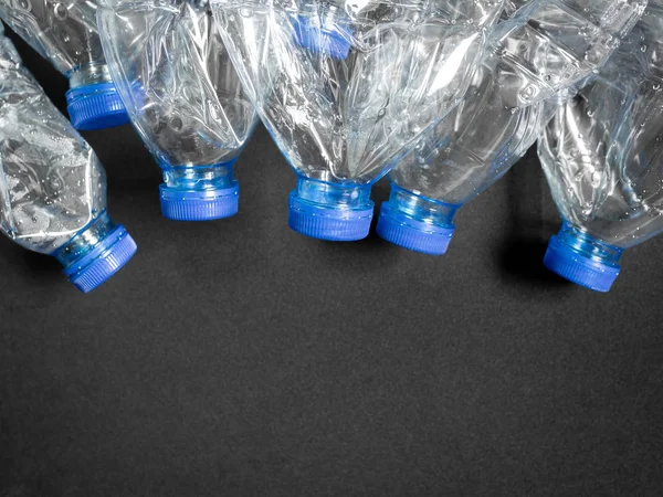 Boş ezilmiş geri dönüşüm plastik içecek su şişeleri üzerinde siyah arka plan kopya alanı ile temizleyin. Küresel ısınma konsepti.