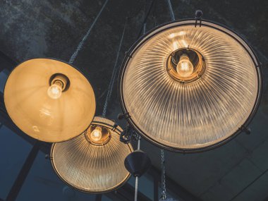 Işıklar asılı veya tavan lambaları loft tarzı kafede çimento doku arka plan üzerinde bir grup.