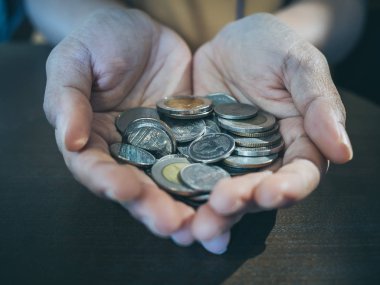 Ahşap masa arka plan ellerinde paralar kapatın. Para ve bağış kavramı kaydetme.
