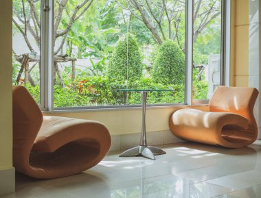 Turuncu kanepe sandalye ve cam masa bekleme odasında pencere cam ve Bahçe yakın:.