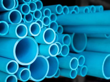 Tüpler Pvc Boru depoda yığılmış. Mavi Pvc borular arka plan.