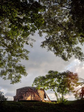 Ormanda günbatımı gökyüzü arka plan dikey stil üstünde belgili tanımlık tepe üzerinde altında yeşil çimenlerin üzerinde kamp çadırı.
