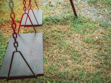 Eski ahşap zinciri salıncak Bahçesi kopya alanı ile yeşil çimenlerin üzerinde.