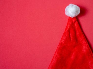 Kopya alanı kırmızı zemin üzerine Santa Claus şapka. Noel minimalist arka plan kavramı.