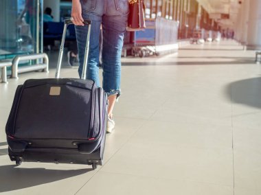 Siyah bavul kopya alanı ile terminal Havaalanı içine yürüyüş ile kot giyen kadın.