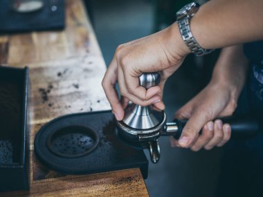 Profesyonel barista kahve telvesi dış müdahale ile Cafe ahşap masa üzerinde tuşuna basarak eller.