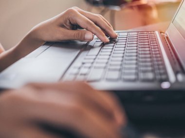 Çalışma ve klavye ile evde siyah dizüstü bilgisayarda office başarı ışık ile yazarak eller.