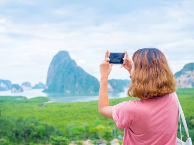 Kısa saçlı smartphone kullanarak pembe gömlek giymiş kadın kopya alanı Tayland Samet Nangshe bakış açısıyla, bir fotoğraf deniz manzarası profili al.