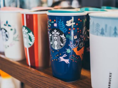 Ayutthaya, Tayland - 7 Aralık 2018: renkli Starbucks kahve Noel seyahat kupalar Starbucks kafede wooedn raflarda ayarla. Starbucks dünyanın en büyük kahvehane şirketidir.