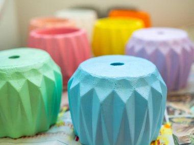 Pastel renkler, açık mavi, yeşil, mor, pembe, turuncu, beyaz ve sarı renkli beton yetiştiricilerinin baş aşağı kağıt üzerinde ışık.