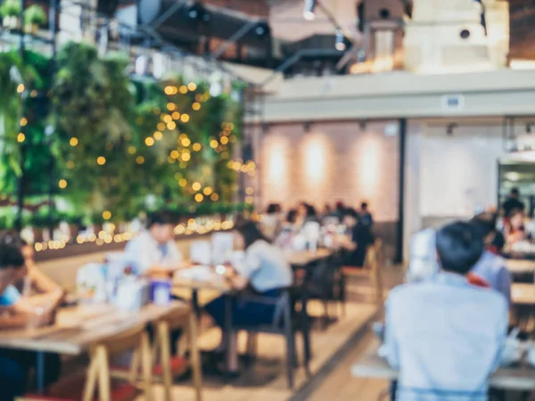 Blurred background of modern restaurant with people. Abstract blurred many people sitting in cafe with bokeh.
