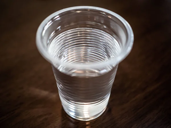 Close Top View Transparent Plastic Cup Water Wood Table Dark — Stok Foto