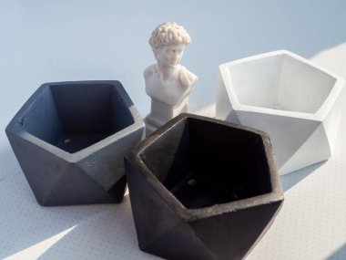 Beyaz arka plan üzerinde küçük David heykeli ile modern geometrik pentagon beton yetiştiricilerinin. Ev dekorasyon minimalist tarzı için boyalı beton tencere.