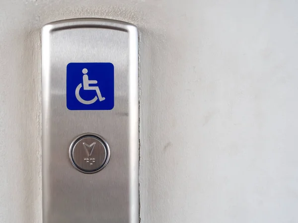 Elevator button with blue disabled people sign on elevator panel