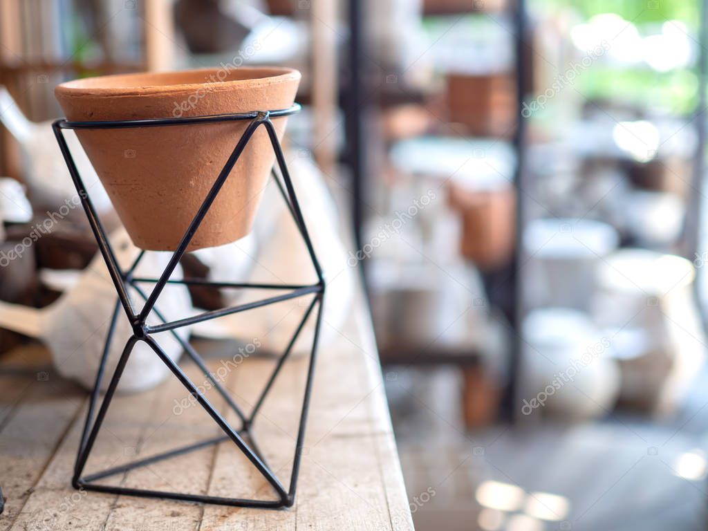 Small terracotta pot in modern black geometric Iron rack holder