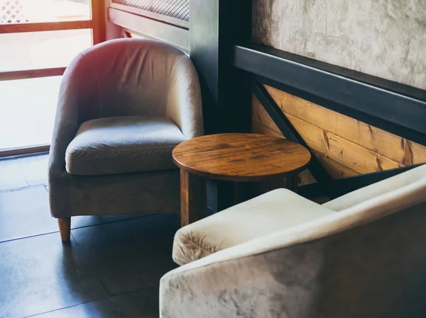 Sillón de tela vintage con mesa redonda de madera cerca de la pared, c — Foto de Stock