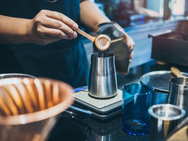 Barista'nın el çekilmiş kahve paslanmaz çelik kahve g içinde koyarak
