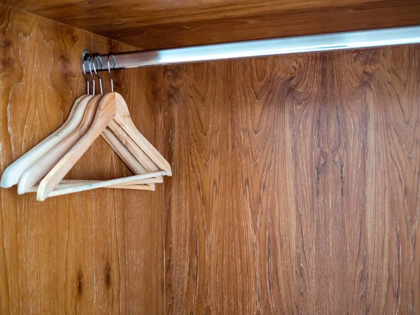 Wooden clothes hangers hanging on stainless steel bar in wooden — 图库照片