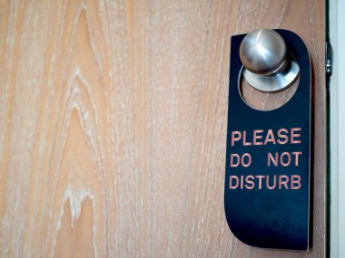 Otel odasının kapalı ahşap kapı ile lütfen işareti rahatsız etmeyin