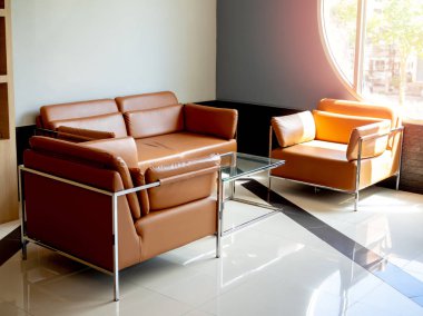 Mavi backgrou üzerinde cam masa ile modern turuncu deri kanepe seti