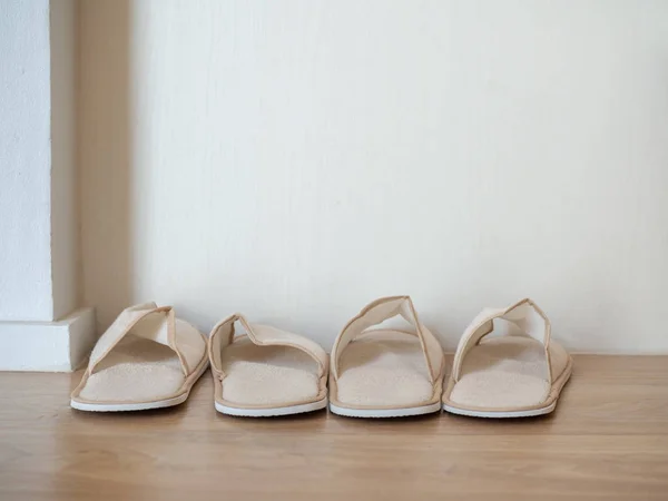 Dos pares de zapatillas blancas suaves en el suelo de madera en la pared blanca b —  Fotos de Stock