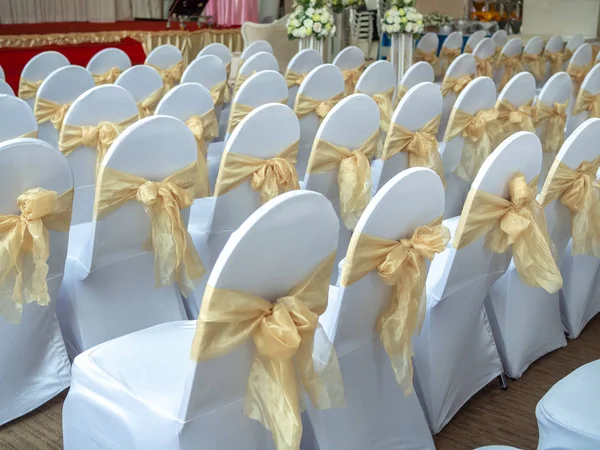 Beautiful white and clean wedding chairs decorated with gold rib