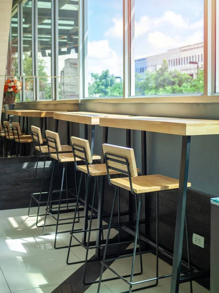 Taburetes de madera y mesa de madera cerca del cristal de la ventana — Foto de Stock