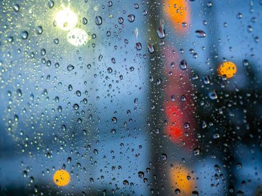 Yağmur renkli bokeh soyut ba ile araba penceresine doku düşer