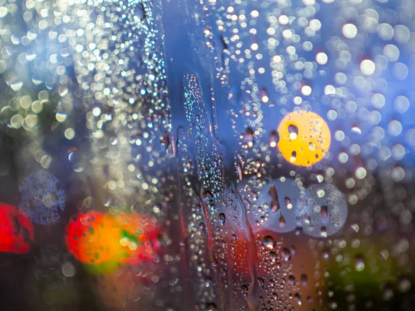 Blurred rain drops texture on car window with colorful bokeh abs