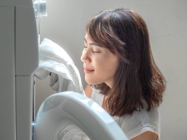 Güzel Asyalı kadın sonra beyaz temiz keten gömlek kokulu oldu