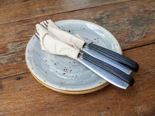 Two set of clean fork and knife wrapped in tissue napkin in the — Stock Photo, Image