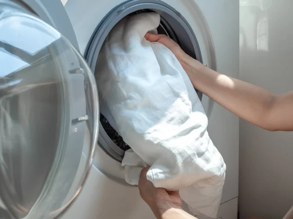 Női kézzel üzembe piszkos fehér vászon inget mosógéppel. — Stock Fotó