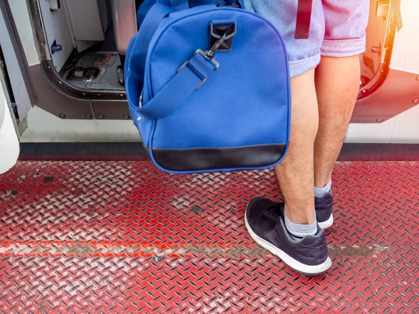 Pasajero sosteniendo el bolso azul de mano caminando hacia la puerta del avión . — Foto de Stock