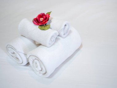 Beyaz temiz yatak üzerinde kırmızı çiçek ile beyaz temiz havlu dekorasyon