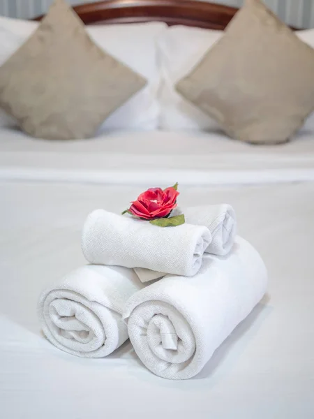 White clean towels decoration with red flower on white clean bed